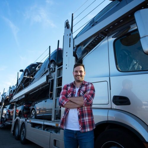 portrait-professional-smiling-truck-driver-with-crossed-arms-transporting-cars-market_342744-1333